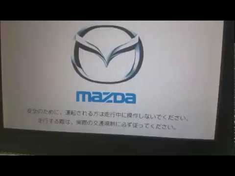 Mazda navigation disk screen showing logo and instructions in Japanese for vehicle GPS update.