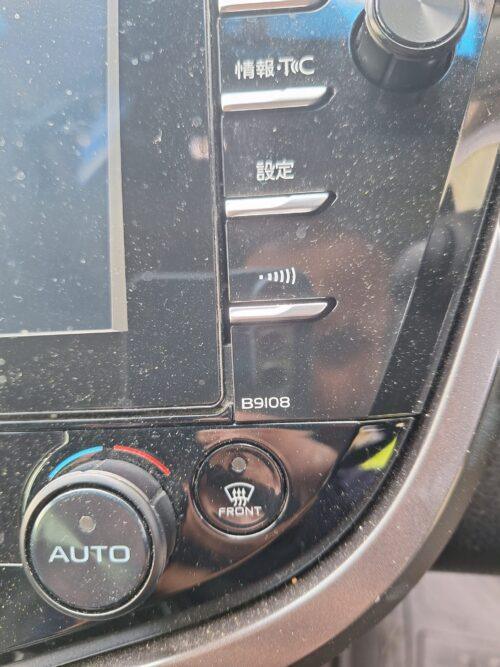 Car dashboard with navigation system and climate control buttons.