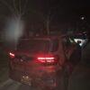 Toyota RAV4 parked at night on a dark street with trees in the background.