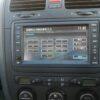 Car dashboard display showing security code input screen for navigation system.