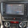 Car multimedia navigation system with touchscreen interface and climate controls.