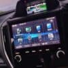 GPS navigation and multimedia system in a car dashboard with touchscreen interface.