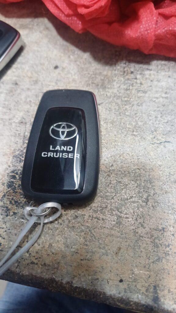 Toyota Land Cruiser key fob with NavigationDisk branding on a textured surface.
