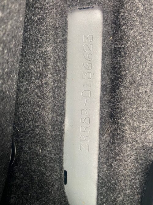Close-up of a metal vehicle identification plate with engraved serial number.