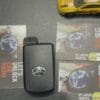 Car key with Toyota logo and promotional cards on a black surface.