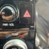 Car dashboard control panel with hazard light button and climate controls.