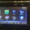 Car multimedia navigation system touchscreen interface with various media options.
