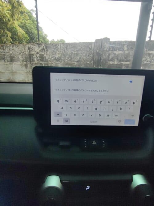 Car dashboard with digital screen displaying security and password input in a vehicle.