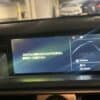 Car dashboard display showing navigation and parking information in a parking garage.