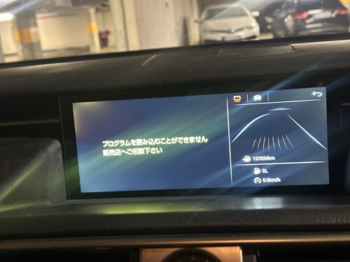 Car dashboard display showing navigation and parking information in a parking garage.