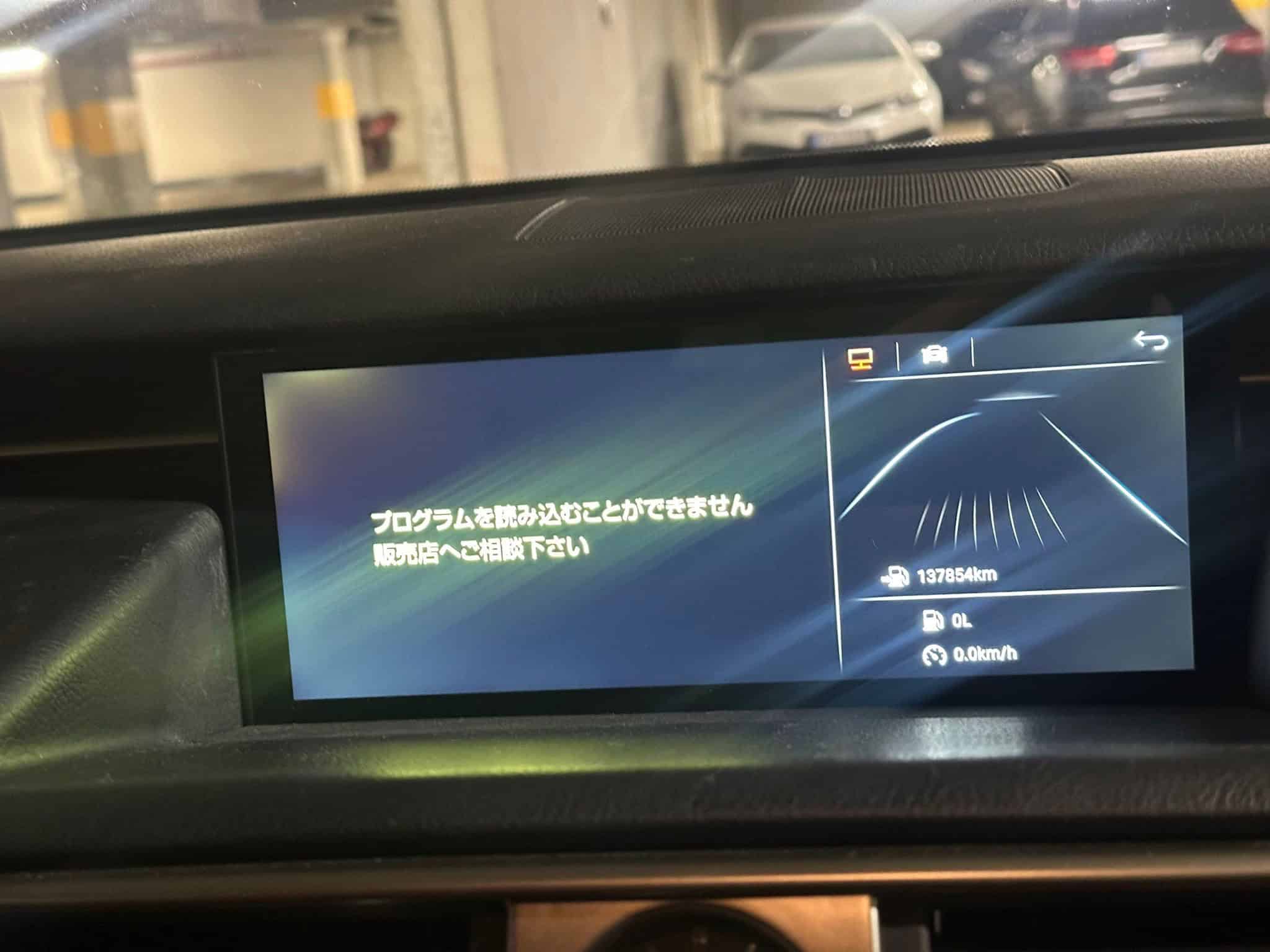 Car dashboard display showing navigation and parking information in a parking garage.