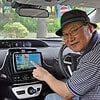 Senior man using GPS navigation system inside a car for driving directions.