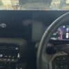 Modern Toyota vehicle dashboard with digital speedometer and steering wheel.